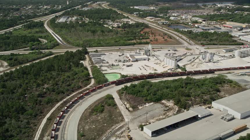 Approaching a quarry in Cocoa Florida from an aerial viewpoint on a partly cloudy day during summer