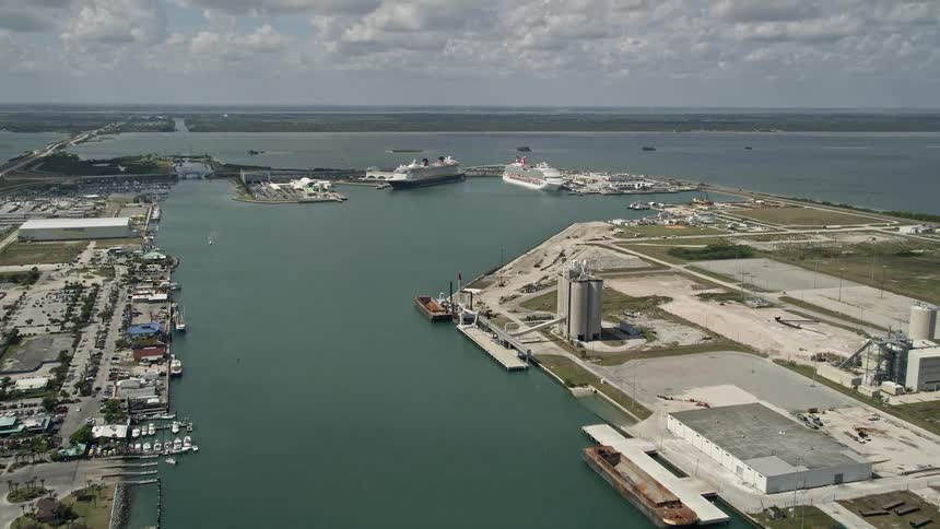 An aerial view of two cruise ships one from Disney and the other from Carnival tilting and revealing in Port Canaveral Florida