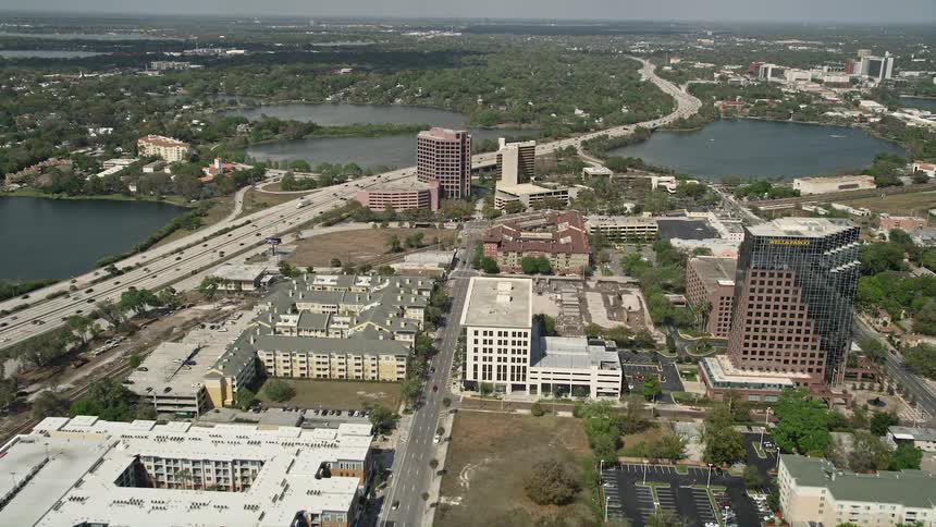 Aerial view of downtown Orlando showcasing its mix of residential and office buildings along North Orange Avenue on a partly cloudy day