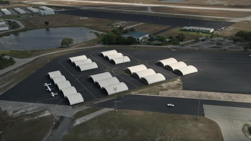 Flying over a row of airplane hangars at Orlando Executive Airport in Florida during the summer