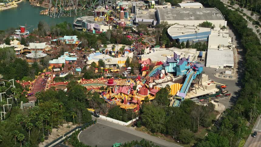 Flying over a water ride at Universal Studios theme park in Orlando Florida surrounded by tall amusement park rides and a highway