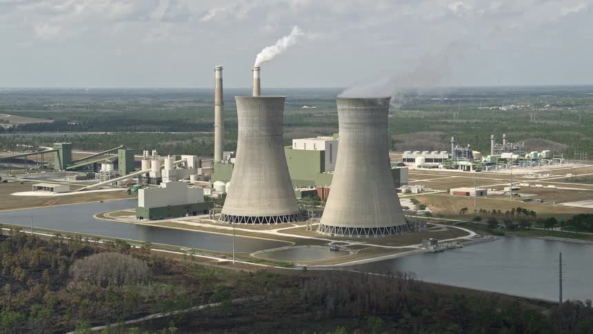 Aerial footage of a coal fired power generation facility on the east coast of Florida during summer showing pollution and partly cloudy skies