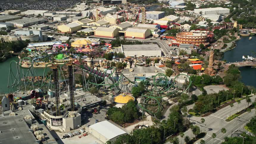 A thrilling side-view aerial footage of the Incredible Hulk Coaster at Universal Studios in Orlando Florida during summer with partly cloudy skies