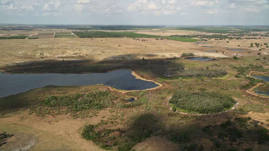Approaching small lakes and farmland are seen from an aerial view in Clermont Florida during the daytime