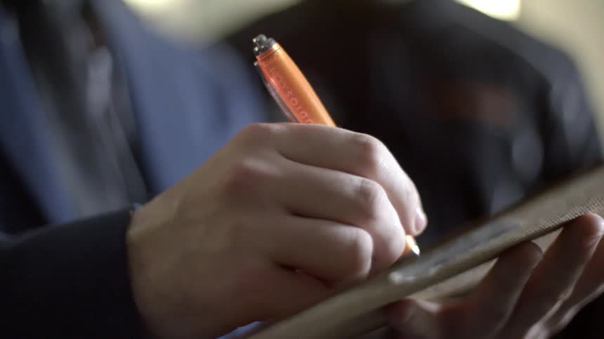 A man uses a pen to mark on a document