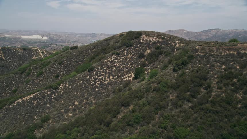 Aerial footage of flying low over mountain ridges in Santa Monica Mountains California on a sunny day
