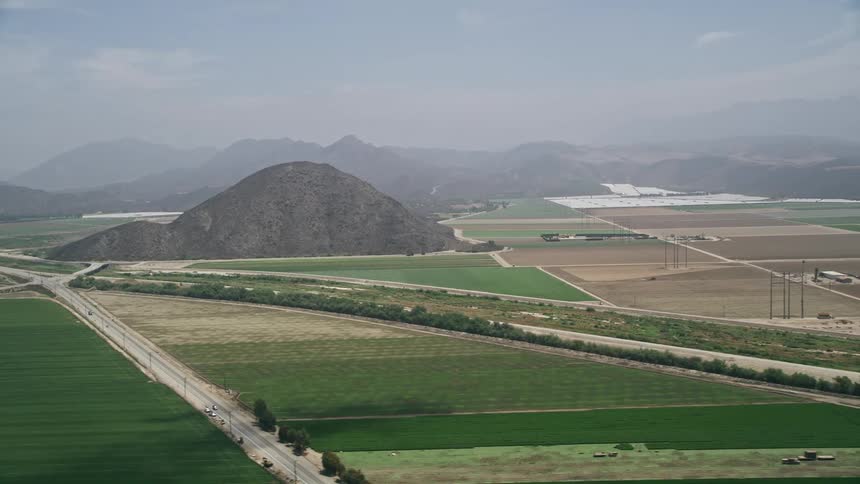 An aerial view of fog-covered farmland with country roads around a steep hill in Camarillo California