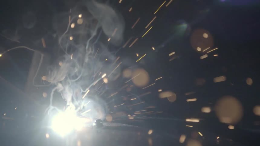 Metal i being welded and sparks are flying