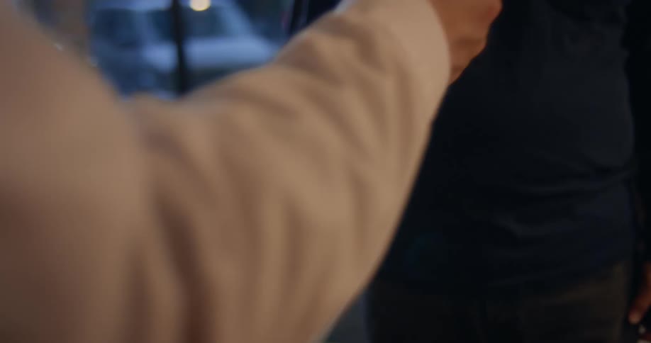 Two people exchanging cash and sealing the deal with a handshake