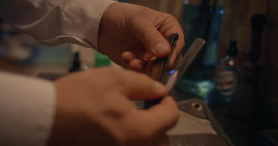 A barber pulls the razor from the tools
