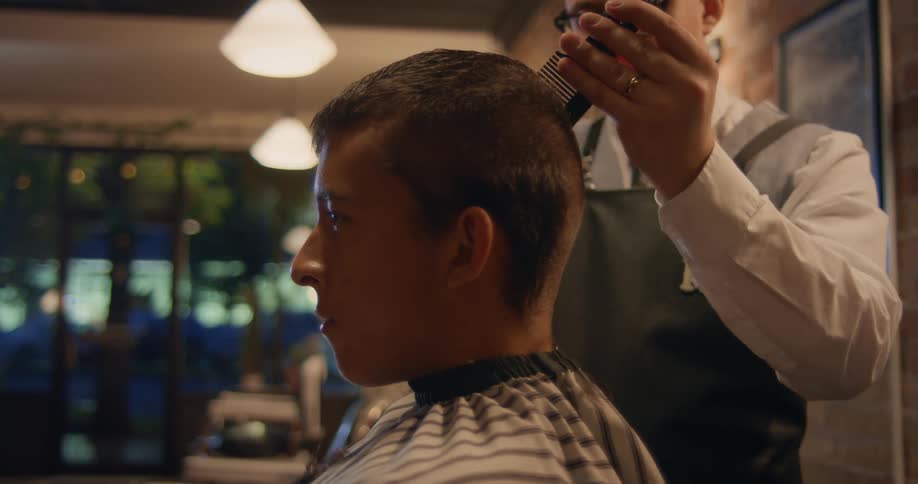 Close up of a hairdresser giving a client a haircut on the barber shop