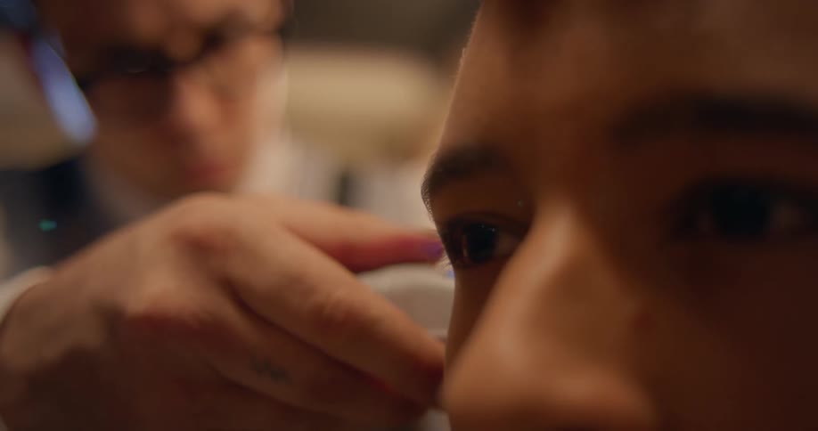 Barber trims hair of man using hair clippers