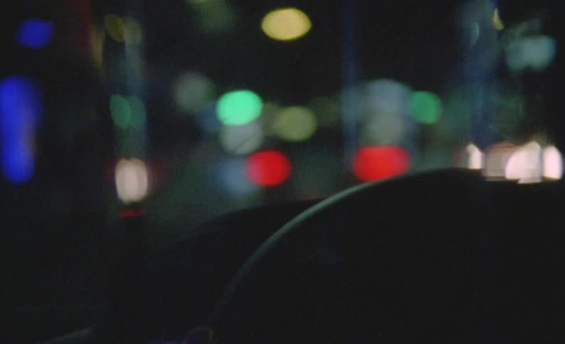 The inside of a vehicle being driven at night by a person whose silhouette is shown