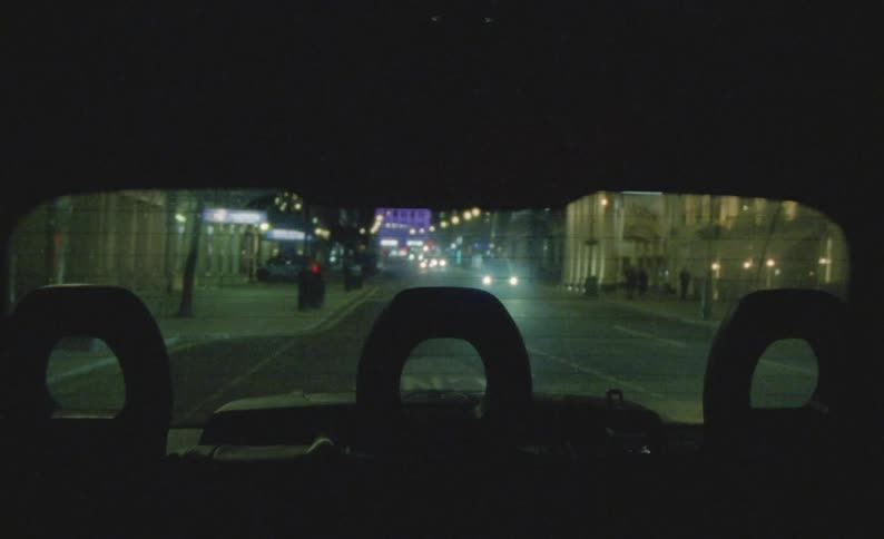 View from the backseat of a car onto a citys nightly traffic