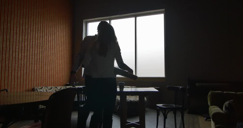 A man and woman hug in a cafe