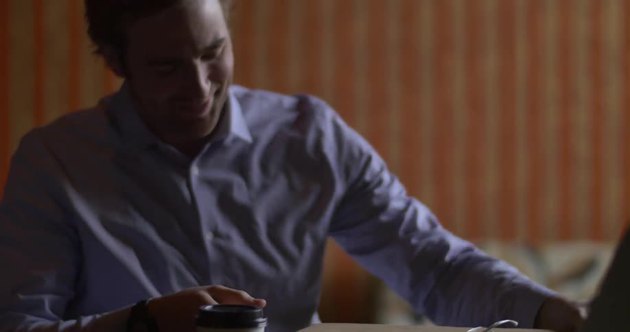 A man and woman sitting at a table and he is receiving a package