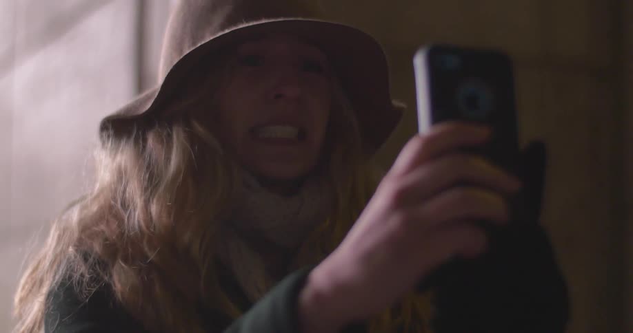 A woman wearing a hat takes a photograph