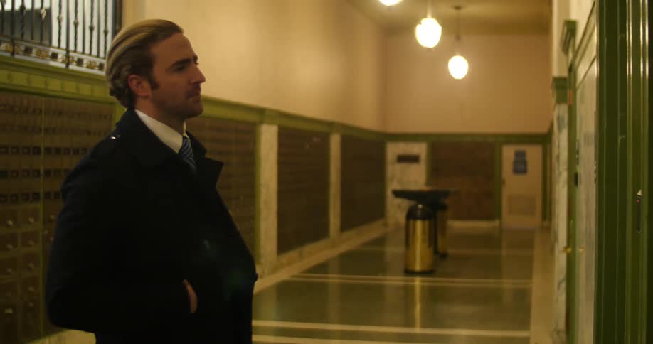 A man walking up to and pressing the button on an elevator
