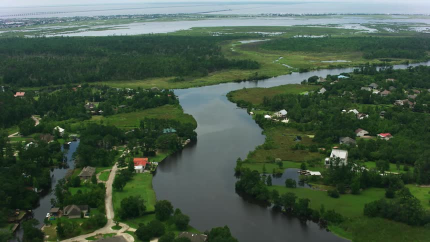 Waterways wind through residential neighborhood near forest a distance from lake
