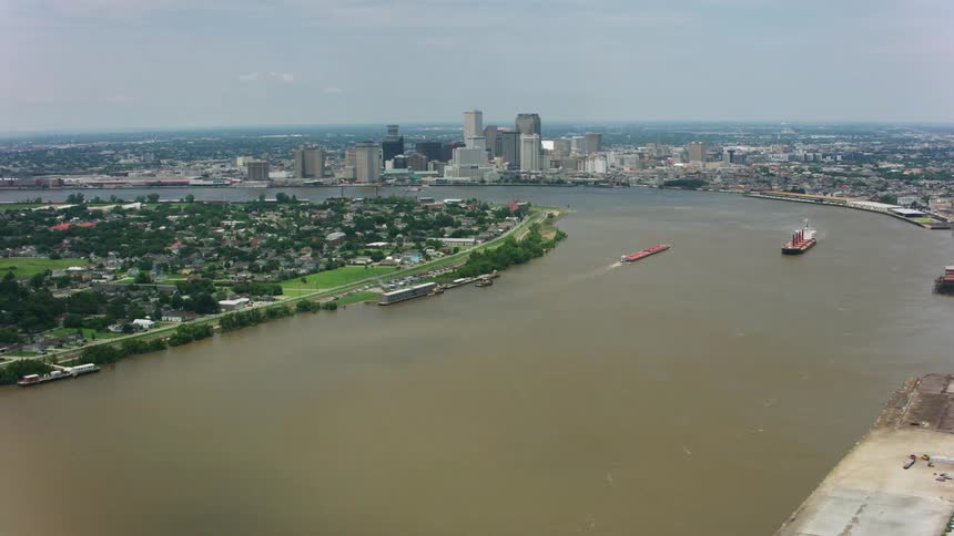 An aerial view of a city and surounding suburbs along a river with a few boats