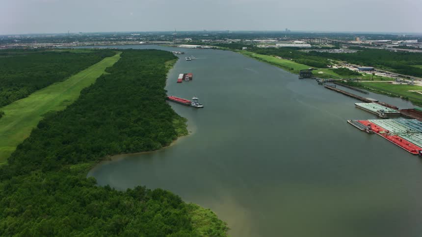 Aerial view of shipping boats on a river through the plains at daytime