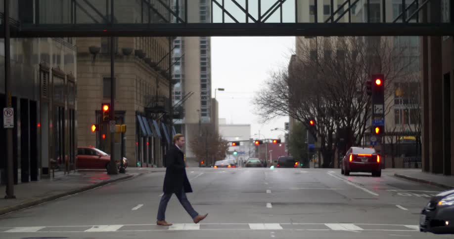 Cars and people travel on a city street