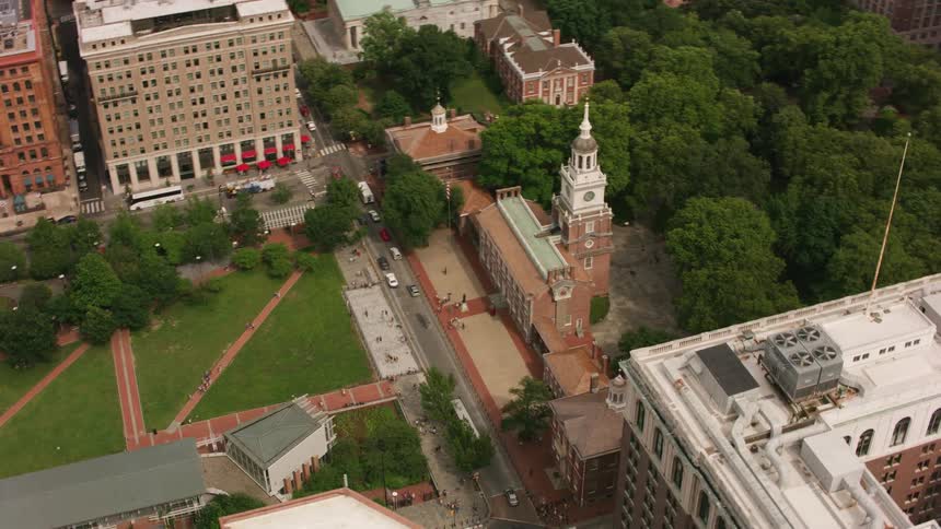 Traffic moves along streets bracketing church and park in middle of city
