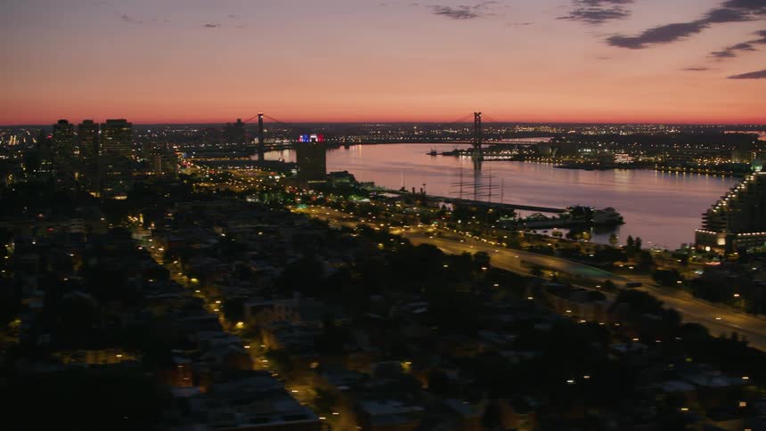 Aerial view of a river through a city under the orange sky at evening