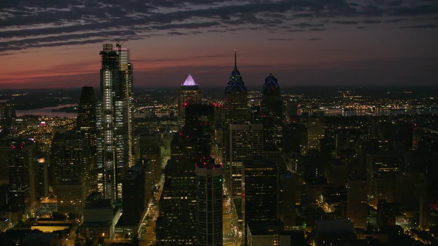Aerial view of tall skyscrapers under a colorful evening sky