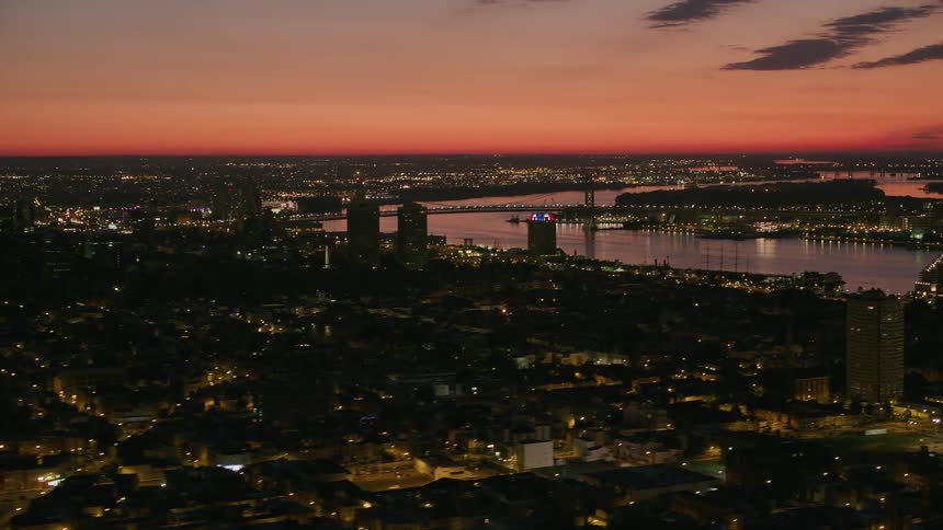 Aerial view of a river flowing through a large city under a red evening sky