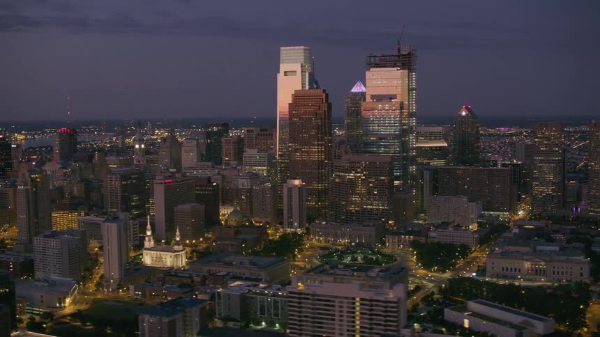 A city skyline at night dominated by six skyscrapers