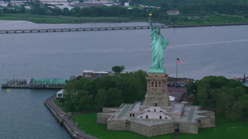 The statue of liberty sits on an island with views of downtown