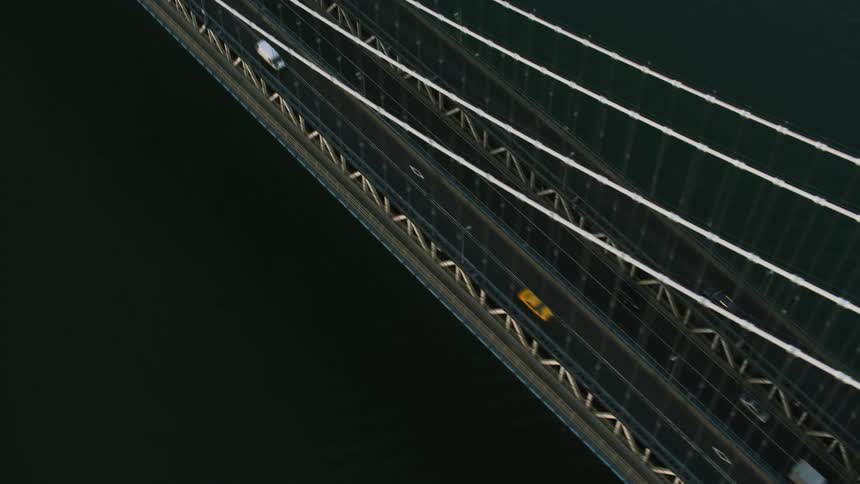 Aerial orbiting view of light traffic over the manhattan bridge at daytime