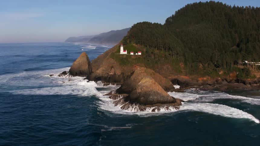 Aerial view of a lighthouse atop a cliff over the coast