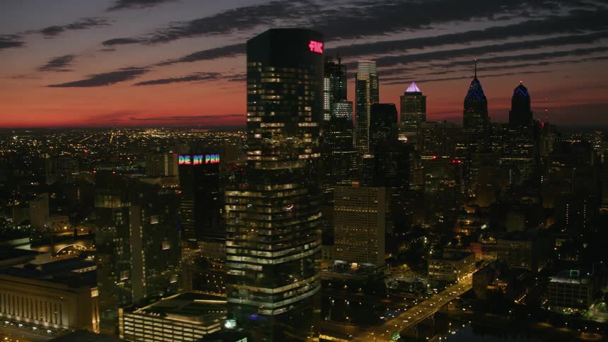 An aerial view of a city with litup towers at dusk