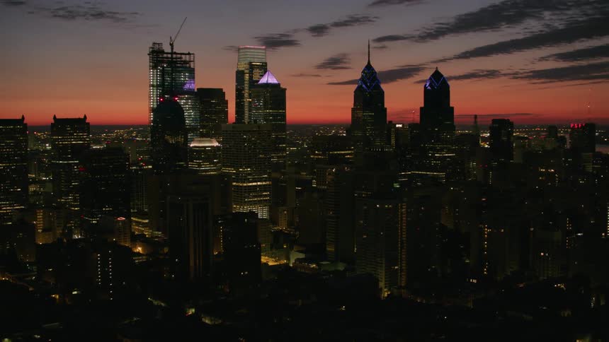 An aerial shot focused on a tower block in a metropolis at dusk