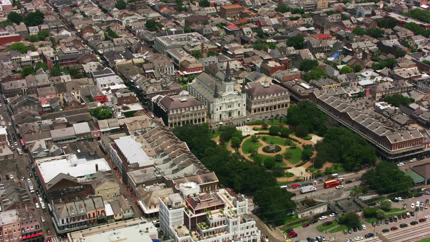 Aerial orbiting view of a church and park next to the sea on a waterfront town