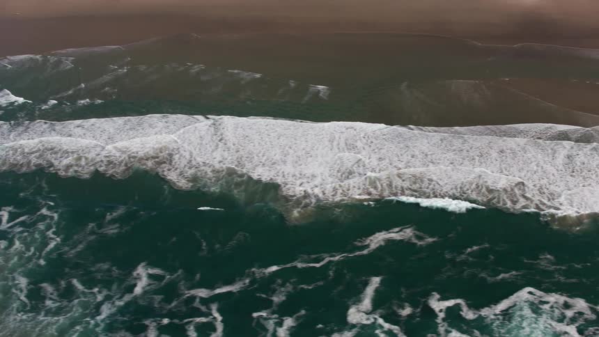 Top down aerial view of sea waves crashing on the coast at daytime