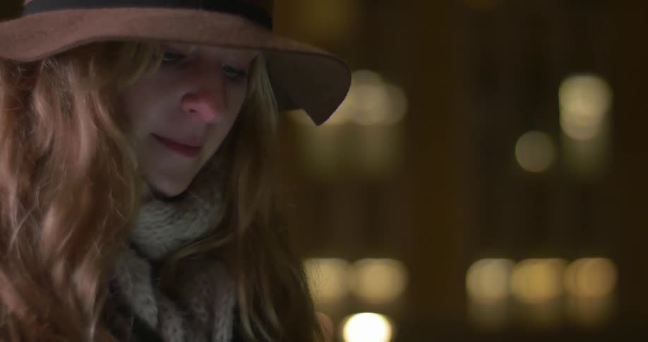 A woman standing outside at night and smiling