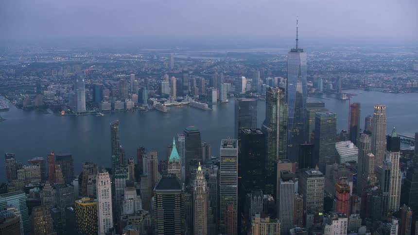 Skyscrapers of varying heights line the waterfront of a dense city