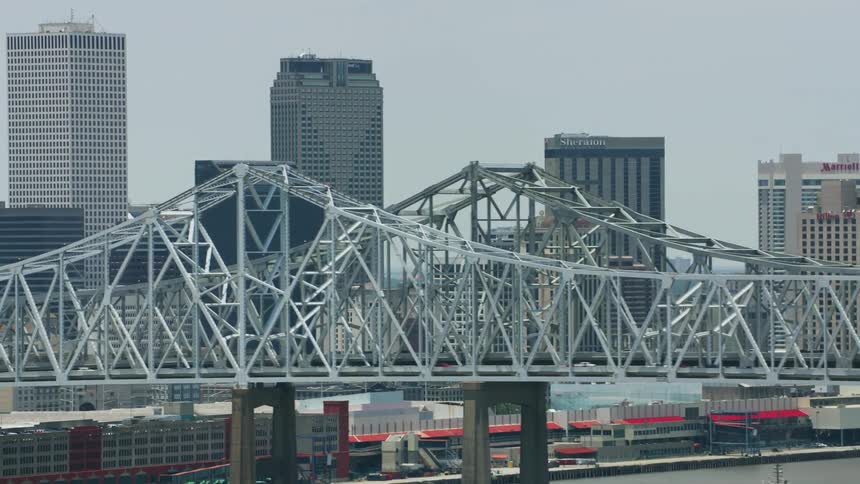 A city skyline dominated by a large metal bridge