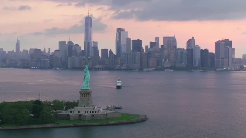 The statue of liberty is on the island by the city