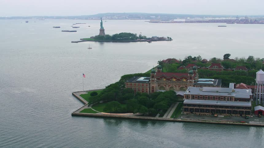 Aerial orbiting view of ellis island near the statue of liberty at daytime