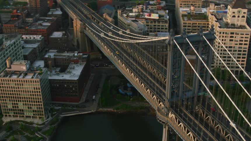 An aerial view of a bridge in a waterfront metropolis and the city skyline