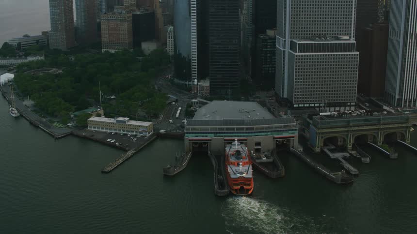 Aerial view of a red cruise ship docking near the city at evening