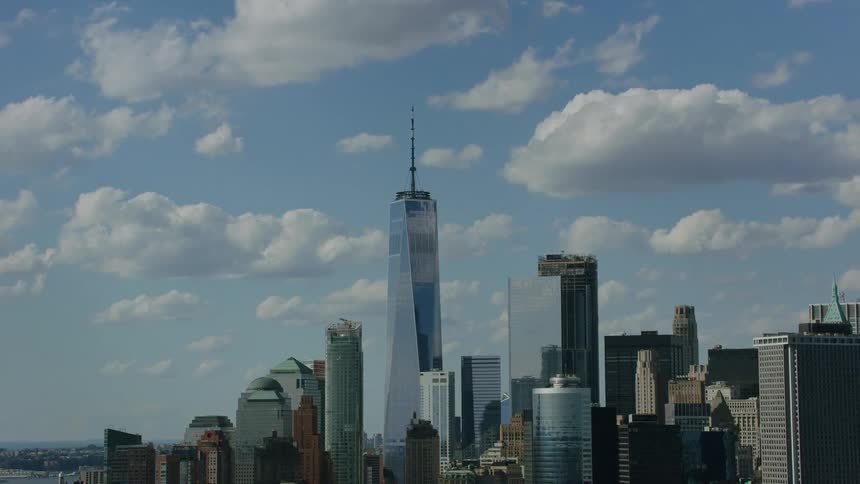 An aerial of a city skyline with tall aesthetic skyscrapers on a blue cloudy day