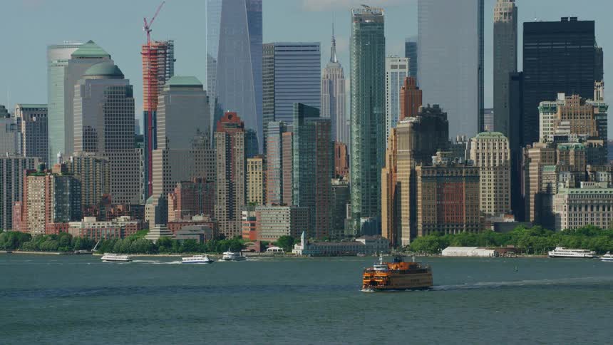 View of the waterfront some boats and the skyline of a metropolitan area on a sunny day