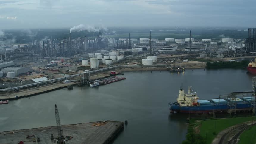 Aerial view of container ships on a river through a large industrial area at daytime