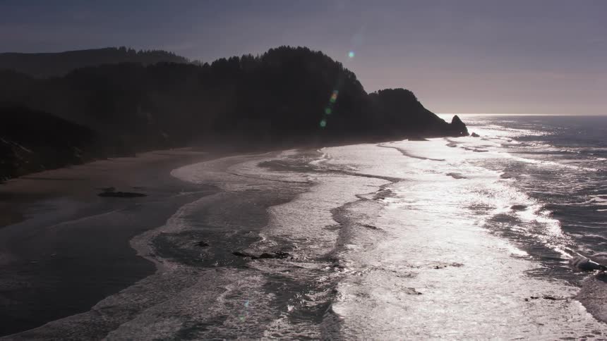 The ocean tide washes into an empty sandy beach during the day
