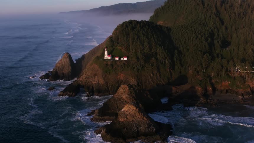A few small white buildings are located at a rocky coastal area